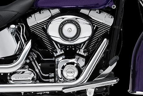 Softail Deluxe / Harley-Davidson Styling pur:    Genießen Sie den unverwechselbaren Look des Twin Cam 103™ Motors, der an seiner Herkunft keine Zweifel aufkommen lässt. Er ist voll und ganz im echten Harley-Davidson Stil gestaltet – mit einer Liebe zum Detail, die Sie bei anderen Marken vergeblich suchen werden. Die schwarzen, pulverbeschichteten Zylinderköpfe und Zylinder bilden einen prägnanten Kontrast zu den polierten Kühlrippenkanten und verchromten Ventildeckeln. Ein aus Metall gefertigtes Juwel: pur und vor Kraft strotzend. Von der klassischen Linie seiner Kühlrippen bis hin zu den klaren Konturen seiner Gehäuse und Deckel ist der Twin Cam 103™ ein rückhaltloses Bekenntnis zu allem, was die Zufriedenheit des Fahrers ausmacht.
