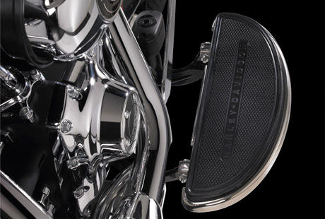 Softail Deluxe / Fahrer-Trittbretter in voller Länge:    Die Möglichkeit, die Fußhaltung zu variieren, sorgt unterwegs für ein entscheidendes Plus an Langstrecken-Komfort. Harley-Davidson Fahrertrittbretter haben sich über Jahrzehnte bewährt. Das Design gestattet jede Menge unterschiedlicher Fußpositionen. Gummi-Elemente entkoppeln die Trittbretter effizient von den Motorvibrationen und gewährleisten so eine komfortable Fahrt. Das Schalten mit Spitze und Hacke ermöglicht jederzeit problemlose Schaltvorgänge. Wenn Sie sich daran gewöhnt haben, werden Sie es nie wieder missen wollen. Und auch die Spitzen Ihrer Stiefel werden weniger leiden.
