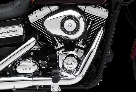 Dyna Super Glide Custom / Harley-Davidson Styling pur:    Genieen Sie den unverwechselbaren Look des Twin Cam 103 Motors, der an seiner Herkunft keine Zweifel aufkommen lsst. Er ist voll und ganz im echten Harley-Davidson Stil gestaltet  mit einer Liebe zum Detail, die Sie bei anderen Marken vergeblich suchen werden. Die schwarzen, pulverbeschichteten Zylinderkpfe und Zylinder bilden einen prgnanten Kontrast zu den polierten Khlrippenkanten und verchromten Ventildeckeln. Ein aus Metall gefertigtes Juwel: pur und vor Kraft strotzend. Von der klassischen Linie seiner Khlrippen bis hin zu den klaren Konturen seiner Gehuse und Deckel ist der Twin Cam 103 ein rckhaltloses Bekenntnis zu allem, was der Zufriedenheit des Fahrers dient.
