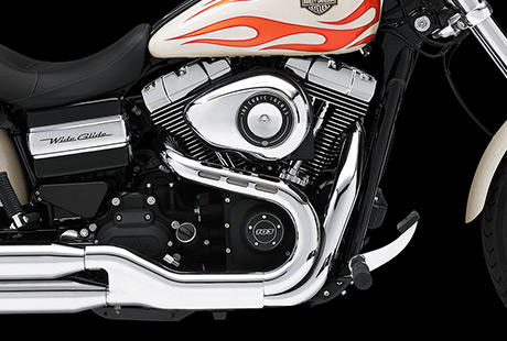 Dyna Wide Glide / Harley-Davidson Styling pur:    Geniessen Sie den unverwechselbaren Look des Twin Cam 103 Motors, der an seiner Herkunft keine Zweifel aufkommen lsst. Er ist voll und ganz im echten Harley-Davidson Stil gestaltet  mit einer Liebe zum Detail, die Sie bei anderen Marken vergeblich suchen werden. Die schwarzen, pulverbeschichteten Zylinderkpfe und Zylinder bilden einen prgnanten Kontrast zu den polierten Khlrippenkanten und verchromten Ventildeckeln. Ein aus Metall gefertigtes Juwel: pur und vor Kraft strotzend. Von der klassischen Linie seiner Khlrippen bis hin zu den klaren Konturen seiner Gehuse und Deckel ist der Twin Cam 103 ein rckhaltloses Bekenntnis zu allem, was die Zufriedenheit des Fahrers ausmacht.
