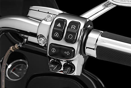 CVO Road Glide Ultra / Ergonomisch ausgelegte Lenkerarmaturen:    Es ist schwer, die Fahrt zu genießen und sich auf den Verkehr zu konzentrieren, wenn die Schalter am Lenker umständlich zu bedienen sind. Deshalb hat Harley-Davidson den Lenkerarmaturen der neuen Touring Maschinen genauso viel Aufmerksamkeit geschenkt, wie dem Rest der Bikes. Sie sind nun ergonomischer gestaltet und exakt so positioniert und ausgerichtet, dass Sie perfekt unter Ihrem Daumen liegen. Harley-Davidson hat eine leicht aktivierbare Geschwindigkeitsregelanlage, griffgünstige Bedienelemente für die Infotainment Funktionen und einen leicht greifbaren Trigger zur Aktivierung der Displayanzeigen angebracht. Zudem wird jetzt jede Tastenaktivierung durch ein vertrauenseinflößendes, fühlbares Klicken bestätigt. Auch der Zündschalter wurde optimiert. Und die elektrische Anlage ist bereits auf das einfache Customizing mit weiterem elektrischen Parts and Accessories vorbereitet.
