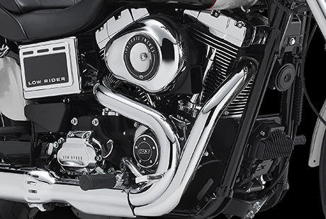 Dyna Low Rider / Twin Cam 103 in Wrinkle Black und Chrome:    Das Herz der Low Rider ist der Twin Cam 103, der in Wrinkle Black und Chrom gehllt ist. Zwischen seinen Zylindern finden Sie einen Pork Chop-Luftfilter. Logisch, dass dieser Motor die Blicke magisch anzieht. Dieses Bike wird berall auf der Welt sofort als eine echte Harley-Davidson erkannt. Sollten daran irgendwelche Zweifel bestehen, wird der Sound sie im Nu zerstreuen.
