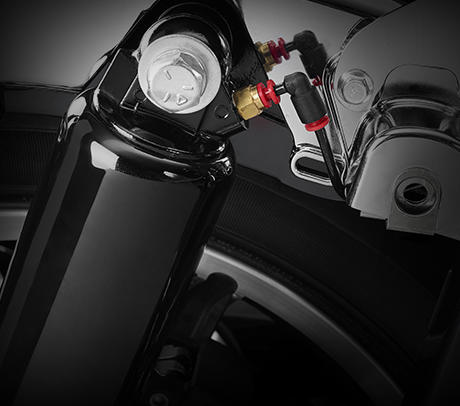 Road King Classic / Fahrwerk mit Luftunterstützung:    Mit der serienmäßigen Luftunterstützung können Sie das Fahrwerk Ihrer Maschine an die jeweilige Beladung, die Fahrbahnbeschaffenheit und Ihre ganz persönlichen Vorlieben angleichen. Reduzieren Sie den Luftdruck, um ein sanfteres Fahrerlebnis zu genießen, erhöhen Sie ihn, um das Fahrwerk härter zu machen. Das Ventil befindet sich zwischen Koffer und Heckfender. Bei dieser Harley-Davidson dreht sich alles um den Komfort – genießen Sie ihn!

